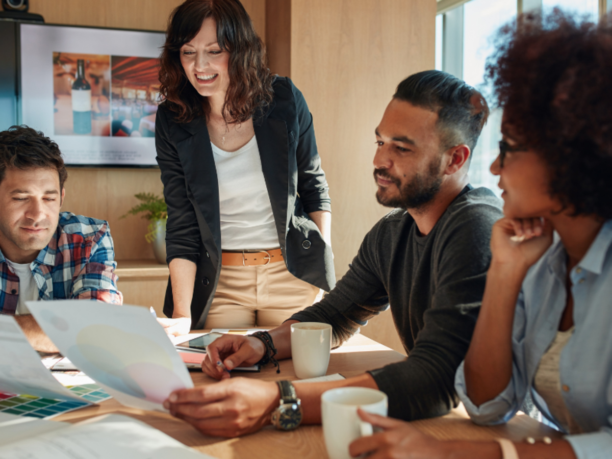 4 people around a table checking some documents.