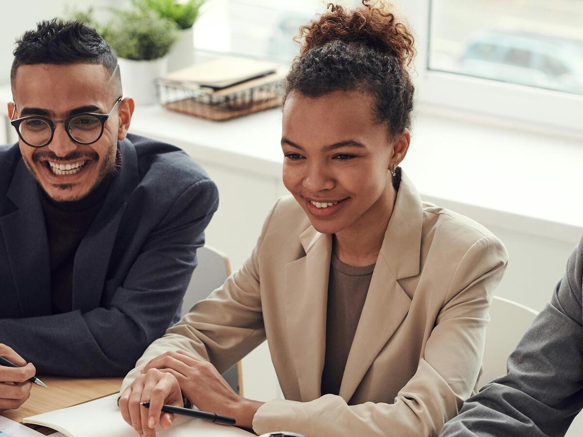 A group of 3 smiling people.