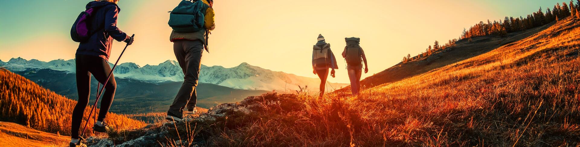 Hikers walking over mountain with sunset