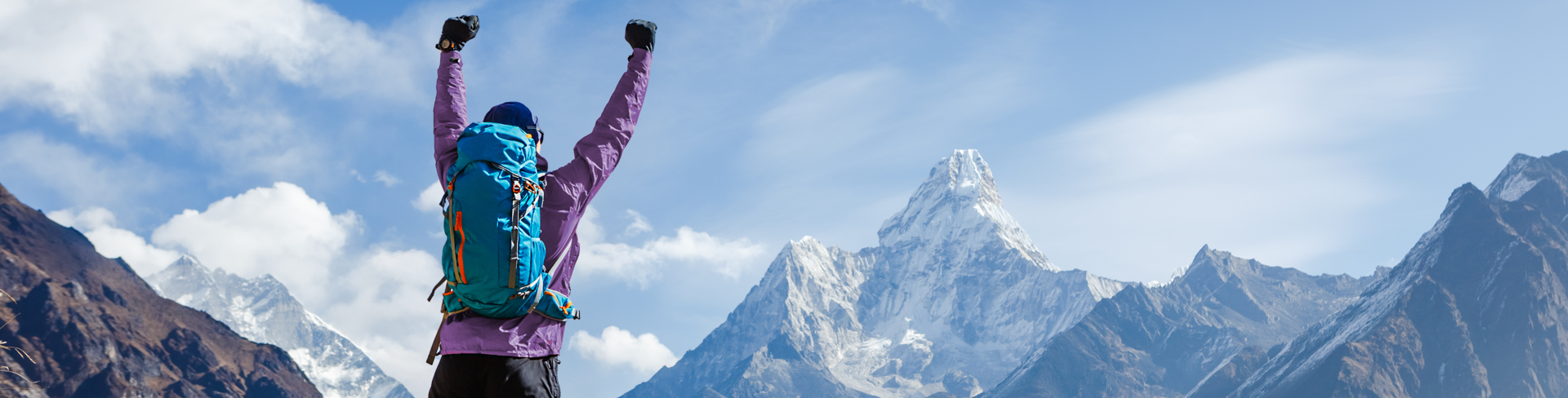 Man on mountain top with arms in the air