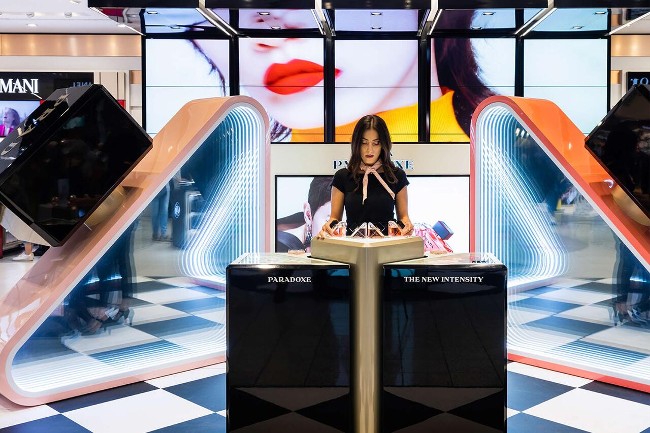 a saleswoman in front of a bright shopping area