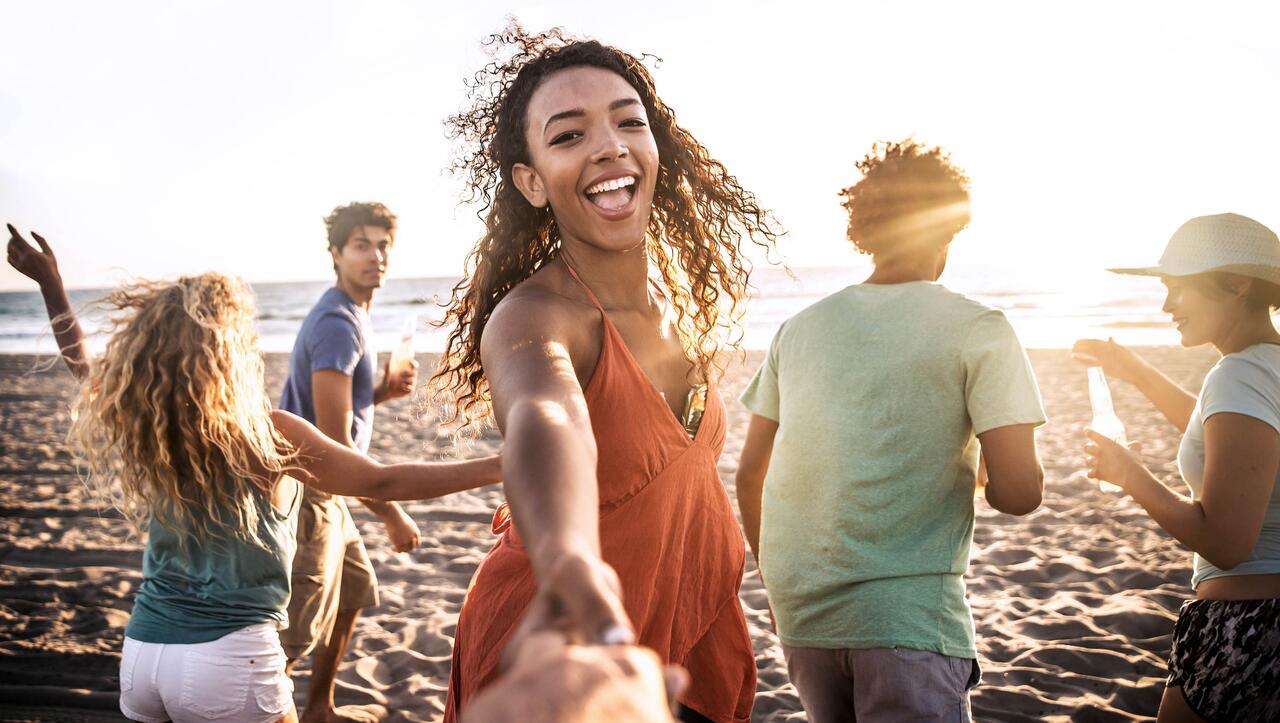 young people dancing on a beach